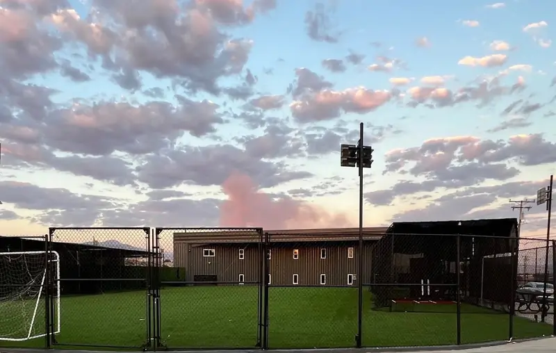 Evening sky over the lit outdoor field and cages at MF Training SB