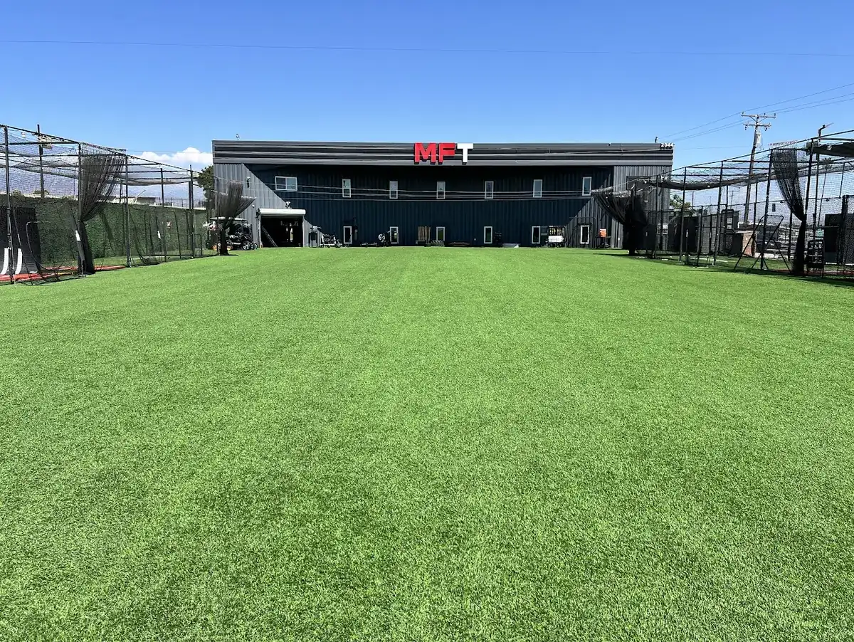 Wide indoor turf field with fresh green artificial grass and lane markings